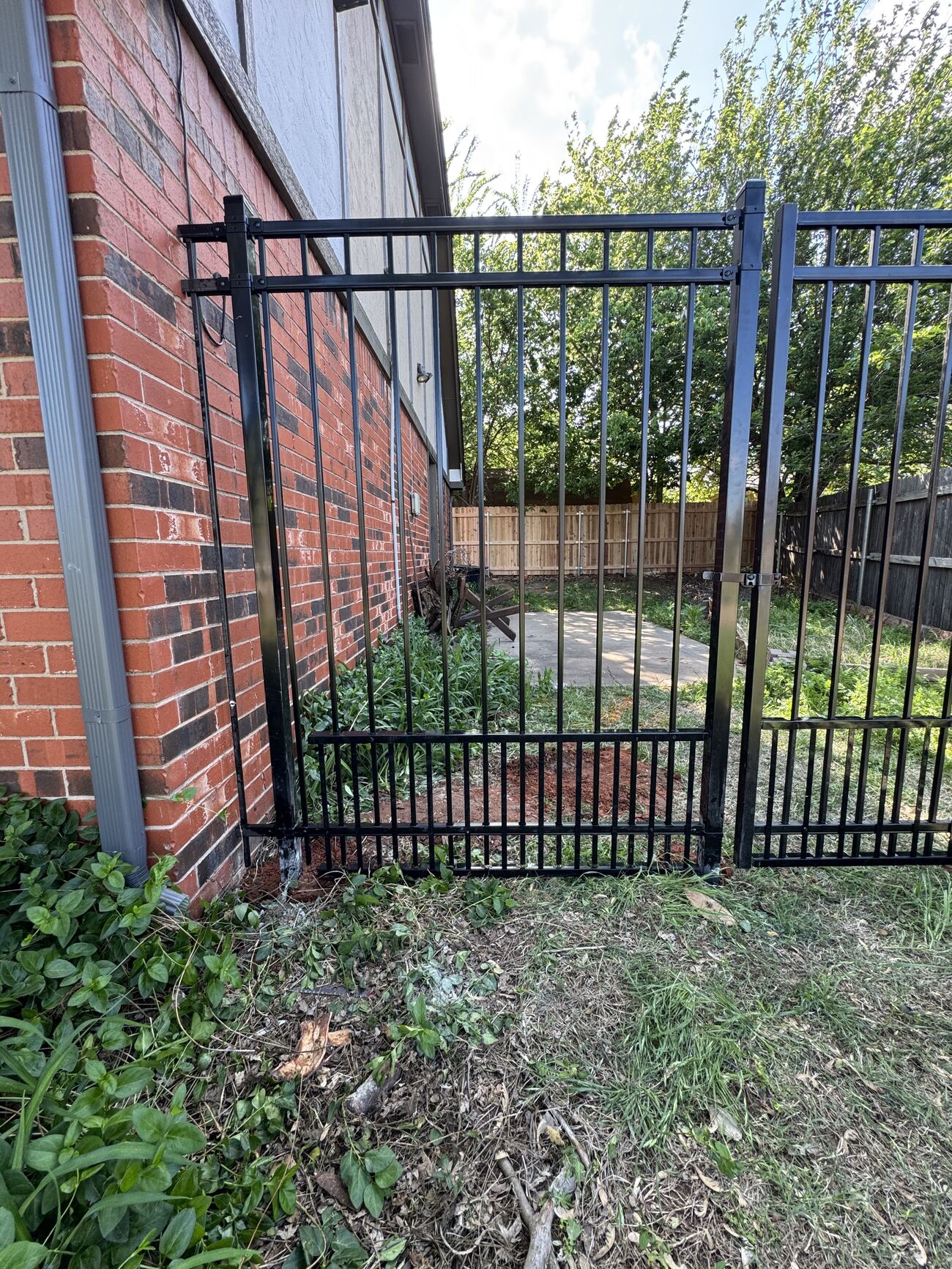 Wrought iron fence along a brick home by SWY Fencing