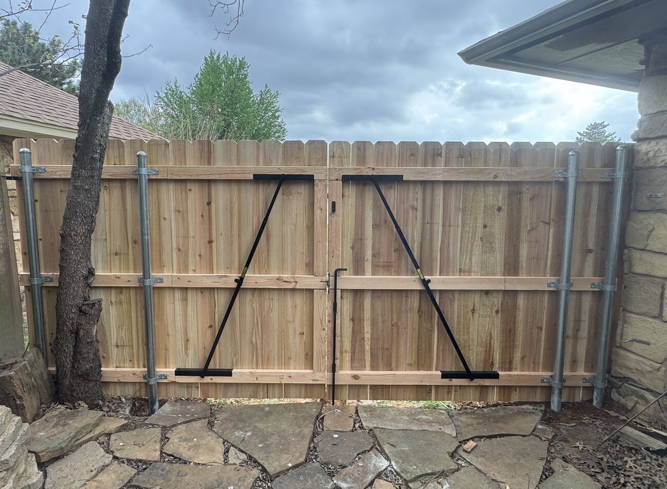 Custom wood gate with stone landscaping by SWY Fencing