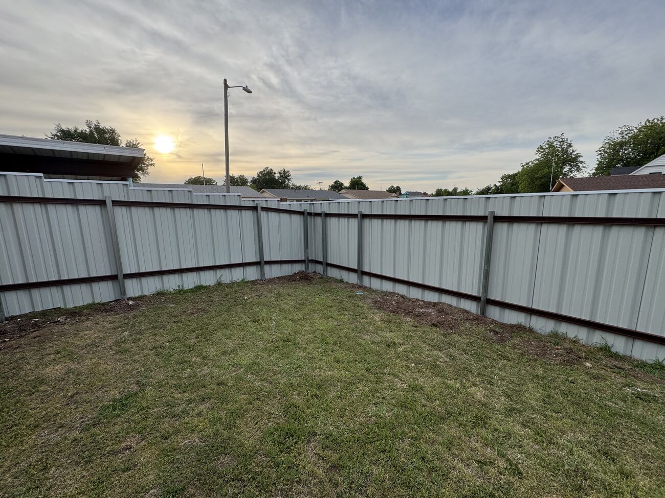 Steel panel fence at sunset by SWY Fencing